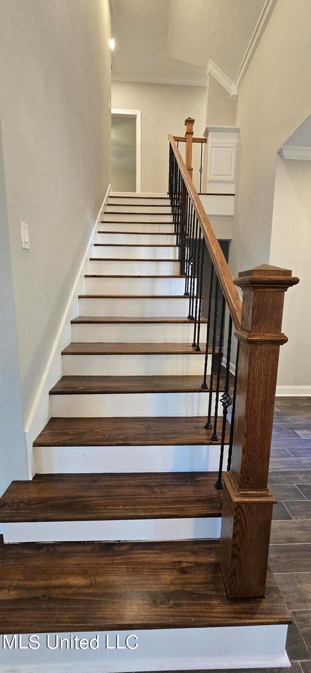 stairs featuring crown molding and wood-type flooring