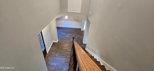 staircase featuring wood-type flooring and a high ceiling