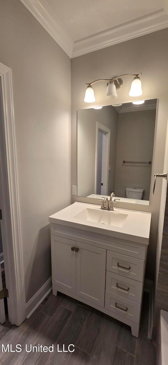 bathroom featuring vanity, hardwood / wood-style flooring, and toilet