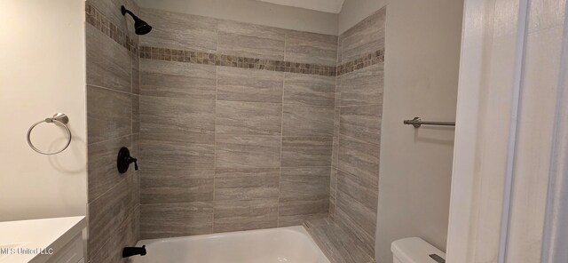 full bathroom with vanity, tiled shower / bath combo, and toilet