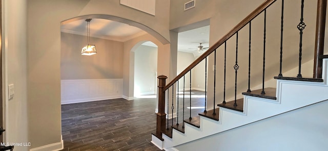 stairs with crown molding, hardwood / wood-style flooring, and ceiling fan