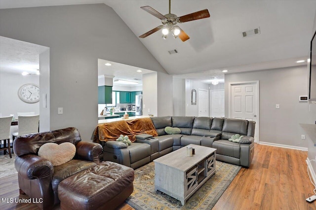 living room with high vaulted ceiling, light wood-type flooring, and ceiling fan