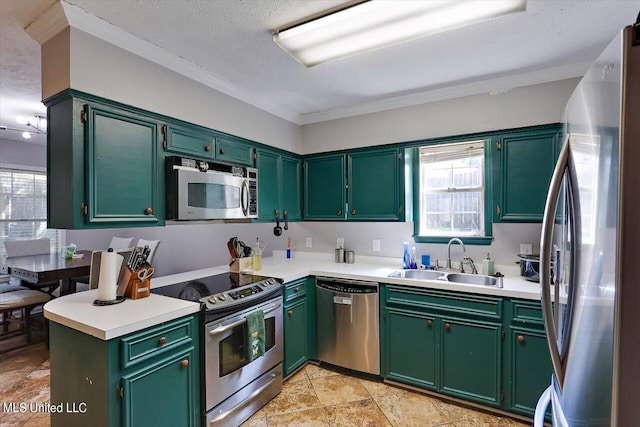 kitchen featuring appliances with stainless steel finishes, crown molding, a textured ceiling, and sink