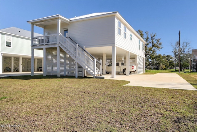 rear view of property featuring a yard, a carport, and stairway