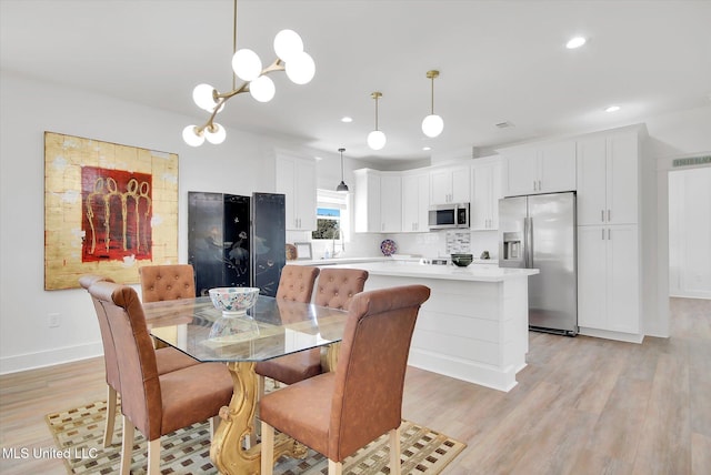 dining room featuring recessed lighting, baseboards, light wood-style floors, and an inviting chandelier