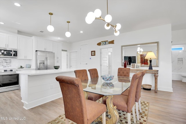 dining area with baseboards, visible vents, light wood finished floors, recessed lighting, and a chandelier