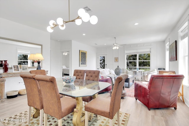 dining area featuring recessed lighting, visible vents, ceiling fan with notable chandelier, and light wood-style flooring