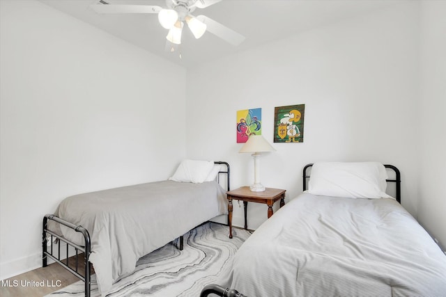 bedroom featuring baseboards, wood finished floors, and a ceiling fan