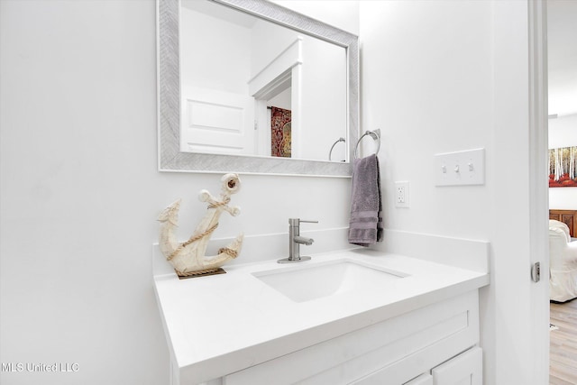 ensuite bathroom featuring vanity, ensuite bathroom, and wood finished floors