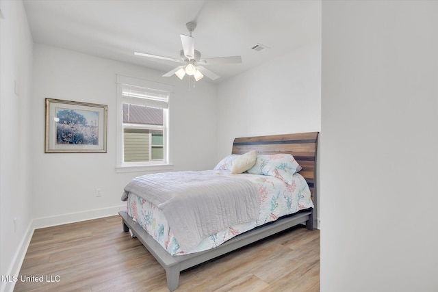 bedroom with visible vents, a ceiling fan, baseboards, and wood finished floors