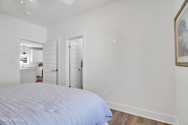 bedroom featuring baseboards and wood finished floors