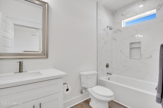 full bathroom with vanity, washtub / shower combination, wood finished floors, baseboards, and toilet