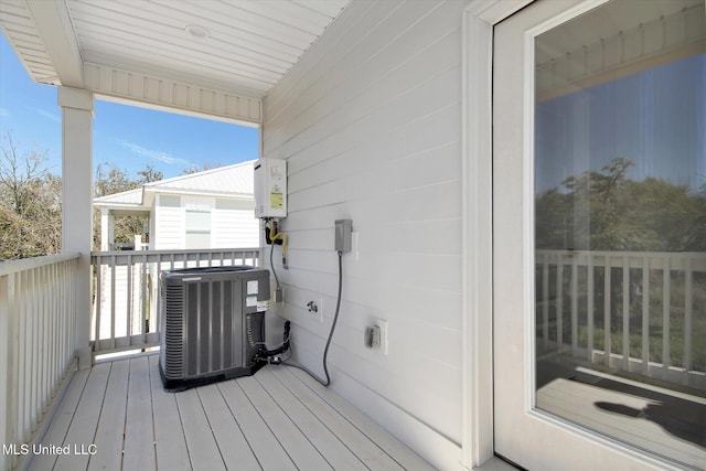 wooden deck featuring cooling unit and water heater