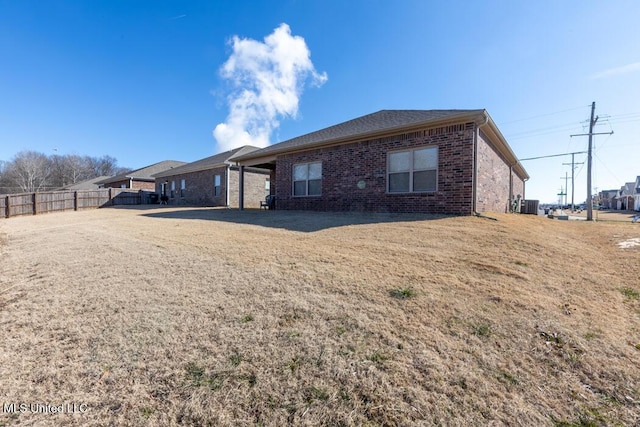 back of house with central AC and a yard