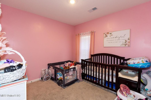 carpeted bedroom featuring a crib