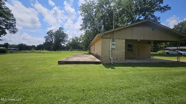 210 Ford St, Como, MS 38619 - view of side of property featuring a lawn, a patio, and brick siding
