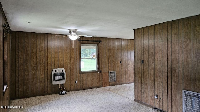 210 Ford St, Como, MS 38619 - empty room with heating unit, wood walls, and a ceiling fan