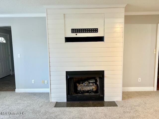 interior details featuring crown molding, a fireplace, carpet, and a textured ceiling