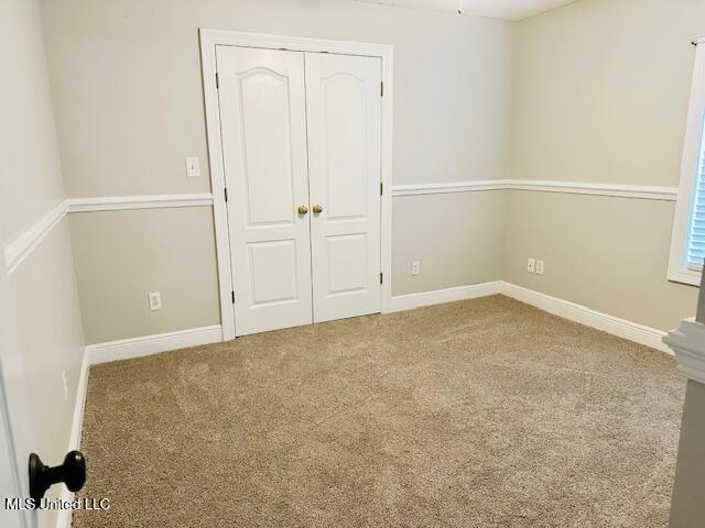 unfurnished bedroom featuring a closet and carpet floors