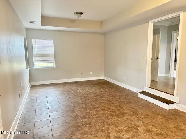 unfurnished room featuring a tray ceiling