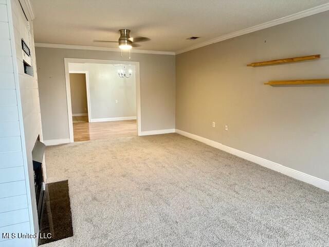 unfurnished living room featuring ceiling fan, light colored carpet, and ornamental molding