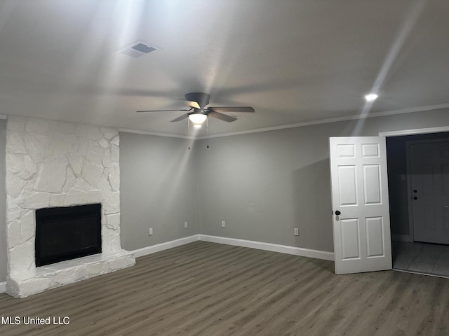 unfurnished living room with crown molding, dark wood-type flooring, ceiling fan, and a fireplace