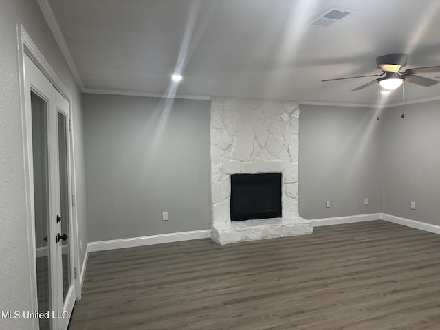 unfurnished living room featuring crown molding, dark hardwood / wood-style floors, a fireplace, and ceiling fan