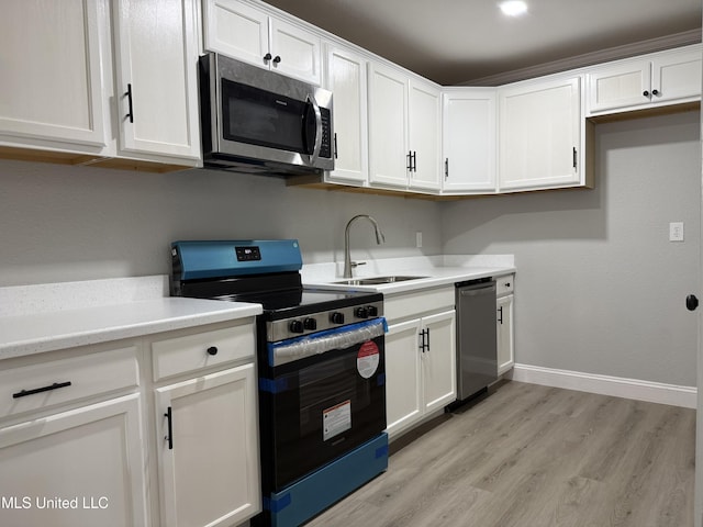 kitchen with white cabinetry, appliances with stainless steel finishes, sink, and light wood-type flooring