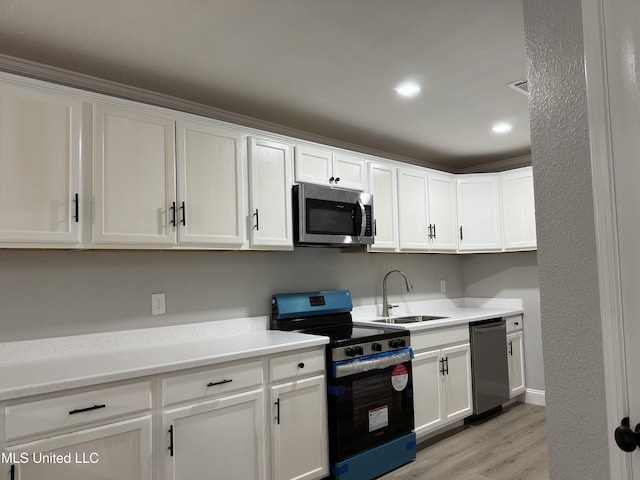 kitchen featuring white cabinetry, sink, light hardwood / wood-style flooring, and stainless steel appliances