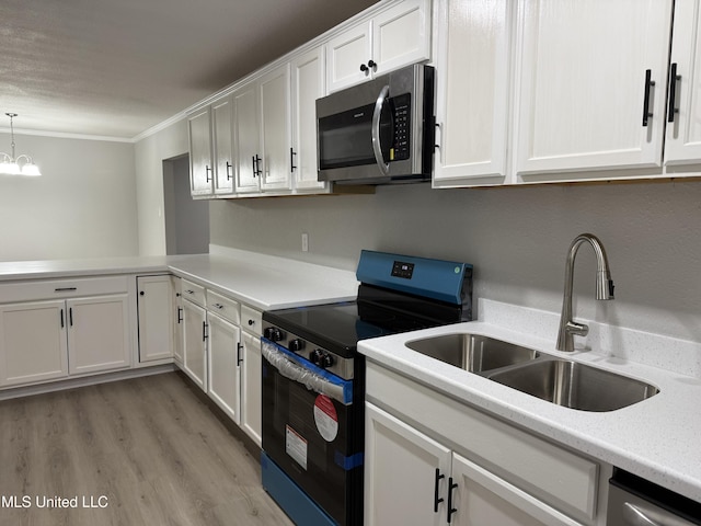 kitchen with pendant lighting, sink, white cabinetry, stainless steel appliances, and light wood-type flooring