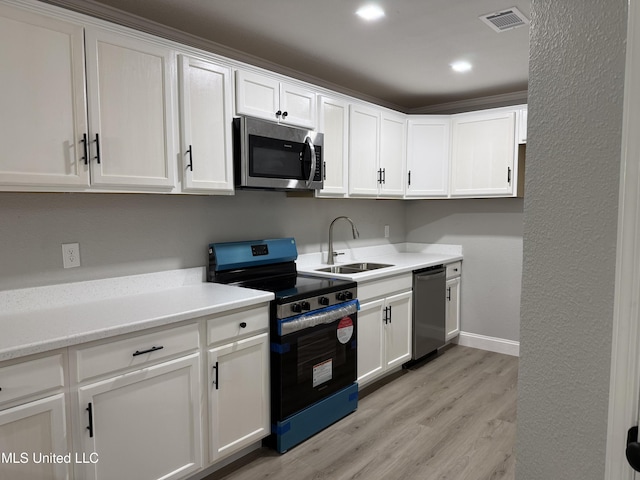 kitchen with white cabinetry, appliances with stainless steel finishes, sink, and light hardwood / wood-style flooring