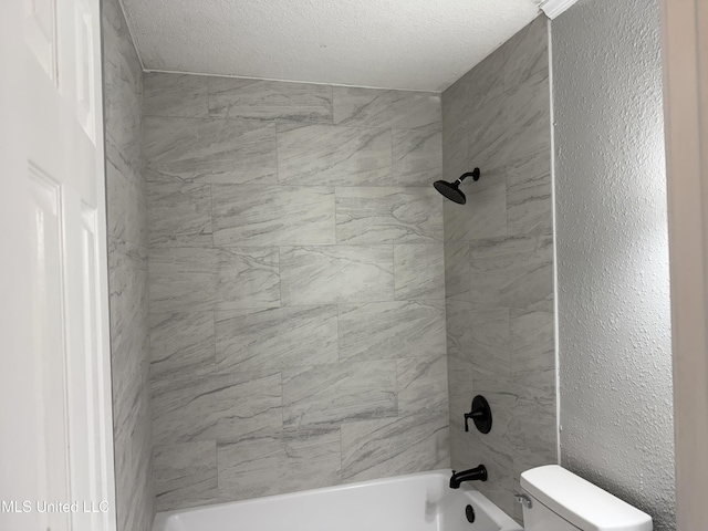 bathroom with toilet, tiled shower / bath combo, and a textured ceiling