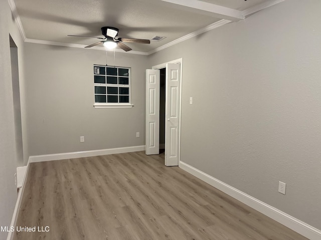 spare room featuring a textured ceiling, ornamental molding, ceiling fan, and light wood-type flooring