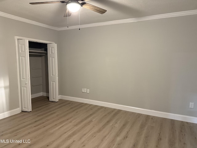 unfurnished bedroom featuring light wood-type flooring, ceiling fan, crown molding, a textured ceiling, and a closet