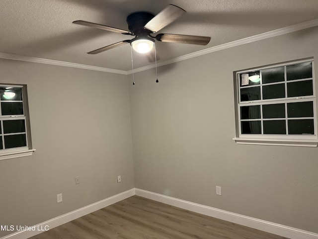 empty room with wood-type flooring, a textured ceiling, and crown molding