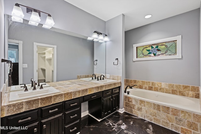 bathroom featuring vanity and tiled tub