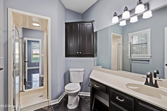 bathroom with vanity, toilet, a shower with shower door, and plenty of natural light