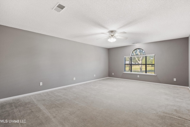 empty room with ceiling fan, carpet flooring, and a textured ceiling