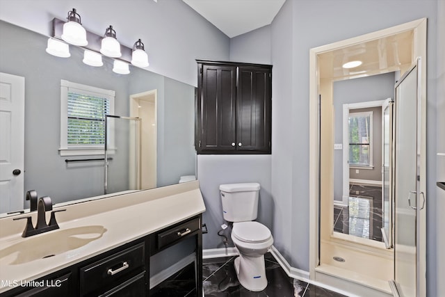 bathroom featuring toilet, vanity, and a shower with door