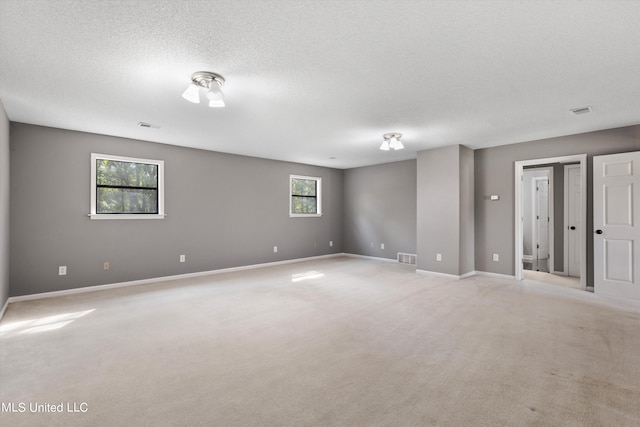 carpeted empty room featuring a textured ceiling