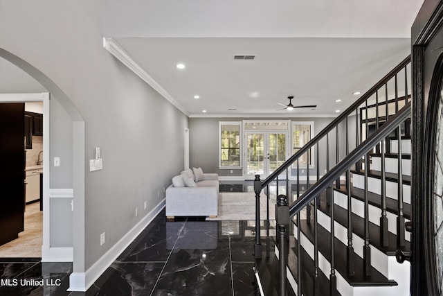 staircase featuring french doors, ornamental molding, and ceiling fan