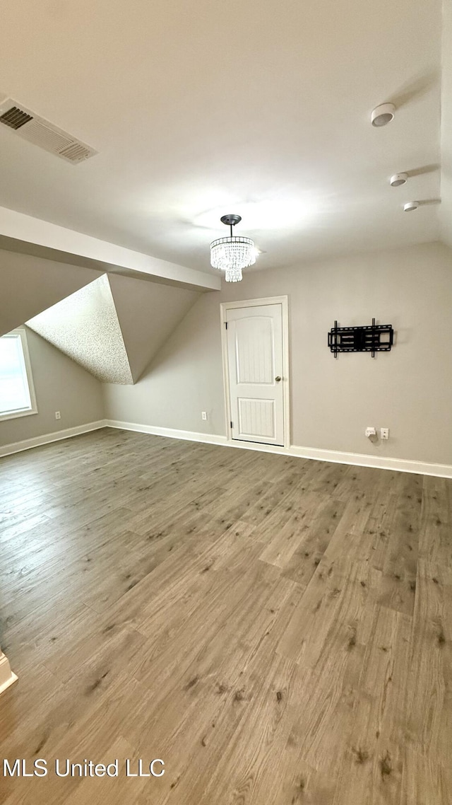 580 Hickory Pl, Brandon, MS 39047 - bonus room featuring lofted ceiling, wood finished floors, and a chandelier