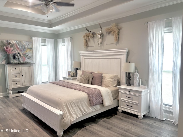 580 Hickory Pl, Brandon, MS 39047 - bedroom with light wood-style flooring, multiple windows, crown molding, and a raised ceiling