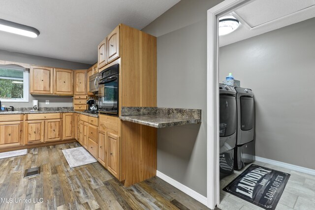 1160 Lucas Rd, Lucedale, MS 39452 - kitchen with independent washer and dryer, oven, baseboards, wood finished floors, and stainless steel microwave