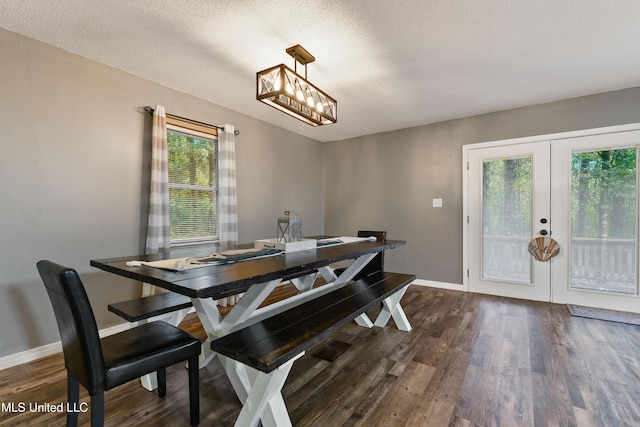 1160 Lucas Rd, Lucedale, MS 39452 - dining space featuring dark wood-style flooring, french doors, a textured ceiling, baseboards, and a chandelier