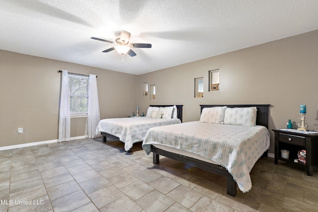 bedroom with ceiling fan and a textured ceiling