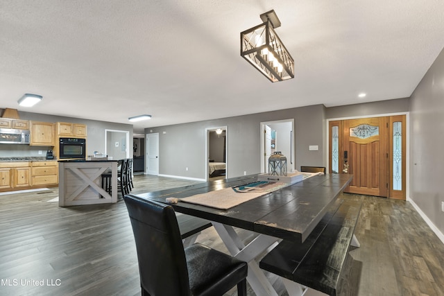 dining space featuring a textured ceiling and dark hardwood / wood-style flooring