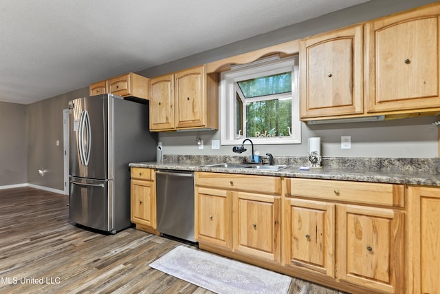 kitchen with sink, light brown cabinets, dark hardwood / wood-style flooring, a textured ceiling, and appliances with stainless steel finishes