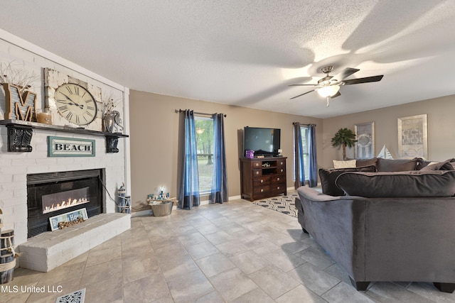 living room with a textured ceiling, a brick fireplace, and ceiling fan