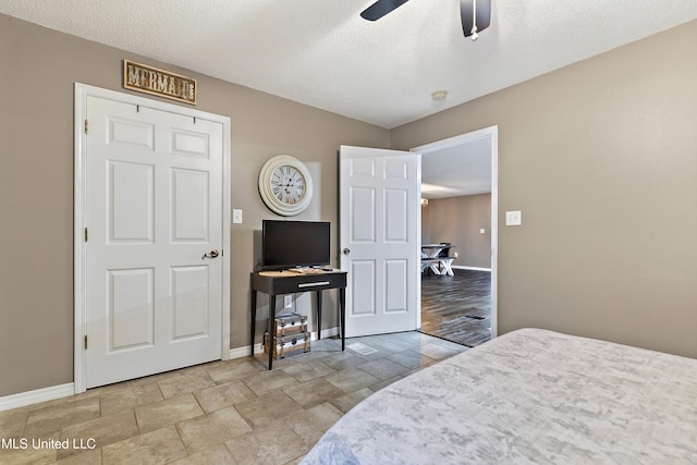 bedroom featuring ceiling fan, a textured ceiling, and light wood-type flooring